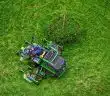 green and black ride on lawn mower on green grass field during daytime
