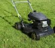 black and yellow push lawn mower on green grass during daytime