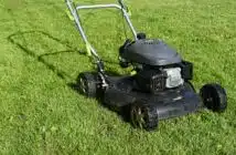 black and yellow push lawn mower on green grass during daytime